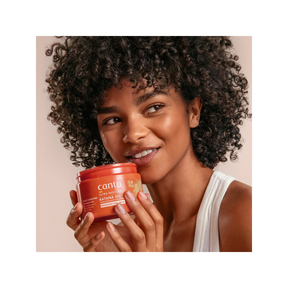 Model holding Cantu Ultra Moisture Nourishing Curl Cream