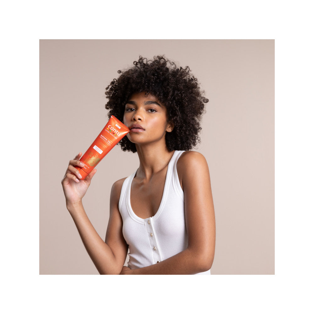 Model holding Cantu Ultra Moisture Leave-In Conditioner