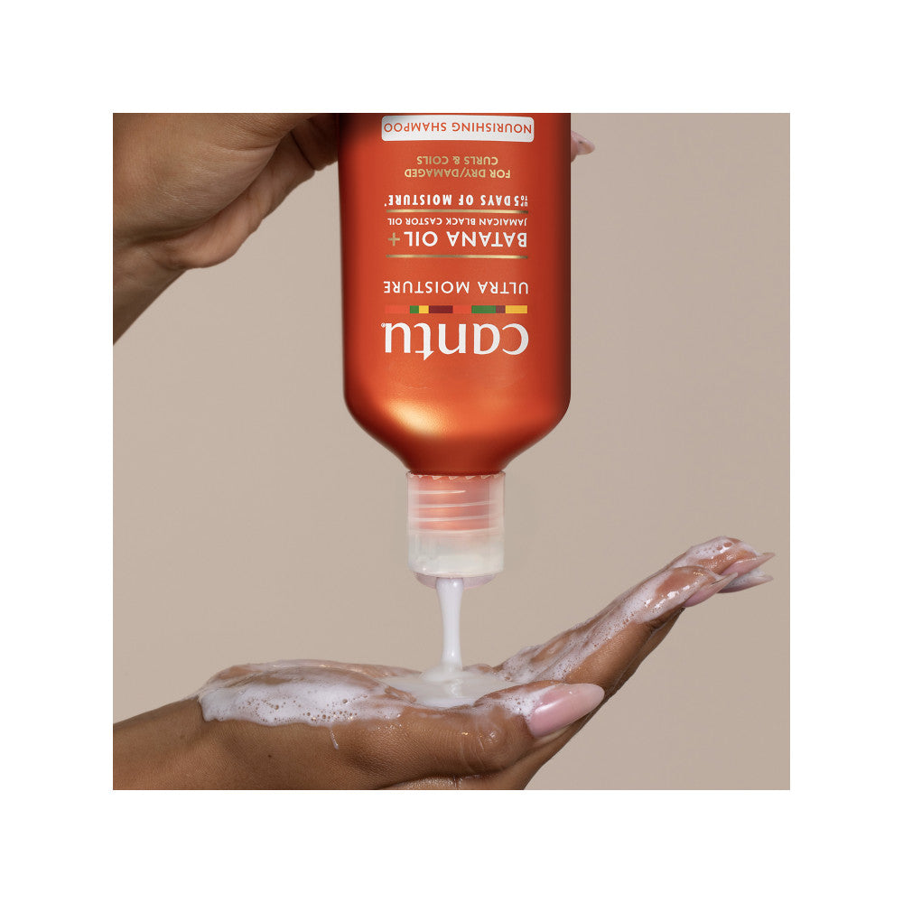 Creamy Cantu Ultra Moisture shampoo dispensed into a hand