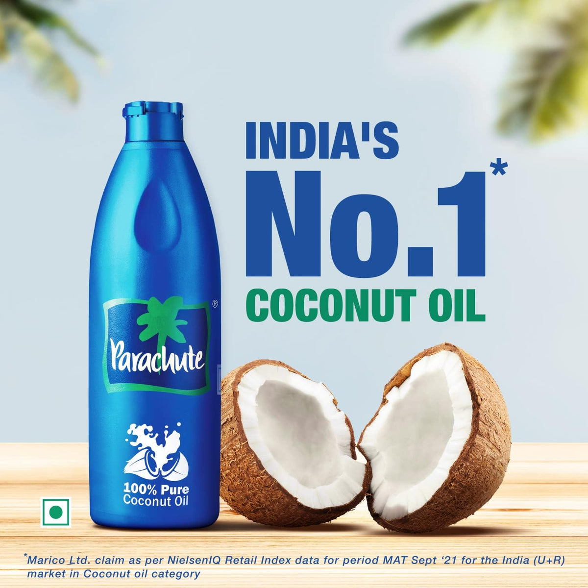 Parachute coconut oil bottle beside two halved coconuts with a caption naming it India's No.1 coconut oil