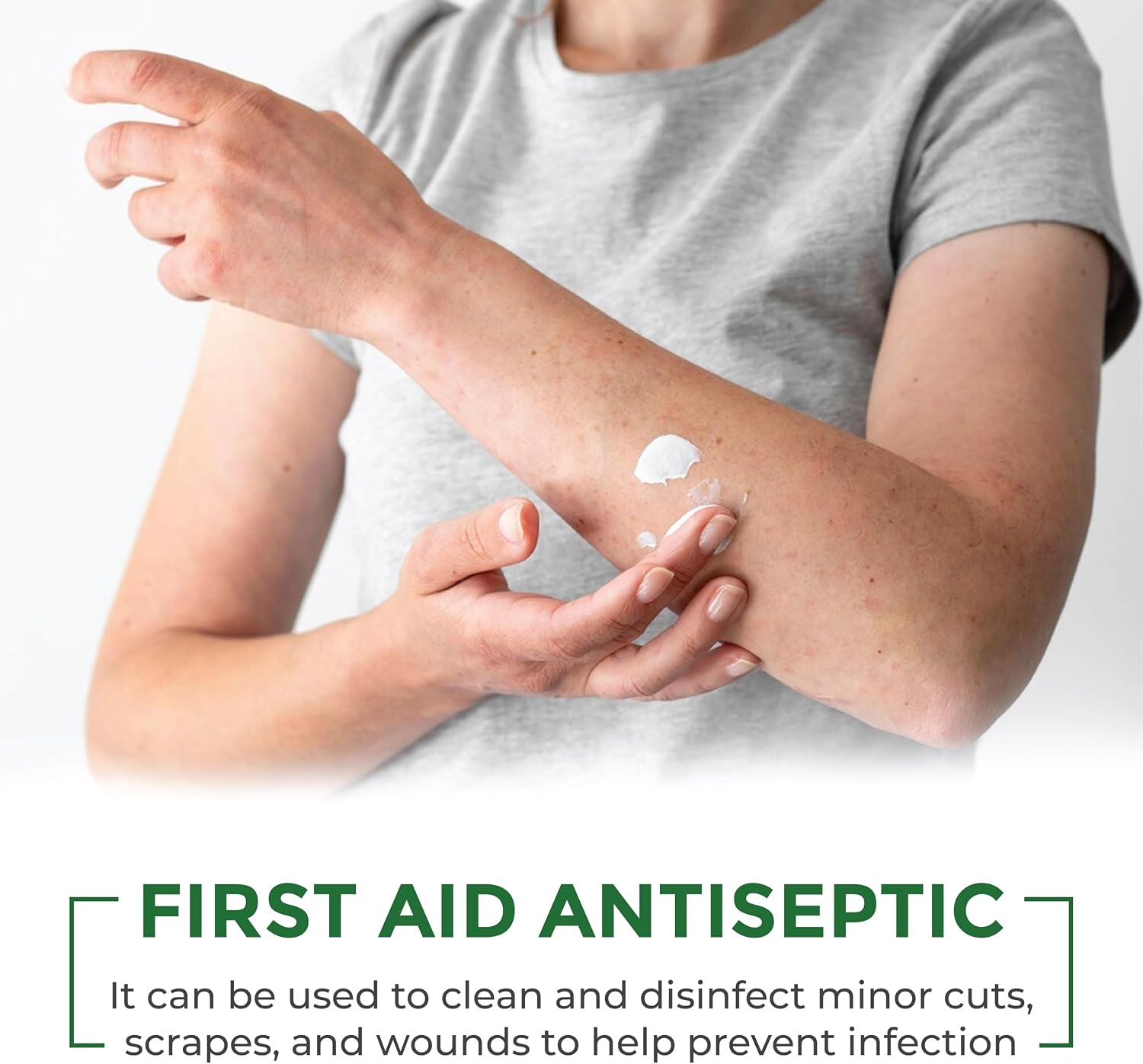 A person applying a white antiseptic cream to their forearm, with text at the bottom reading 'FIRST AID ANTISEPTIC' and a descriptive product callout.