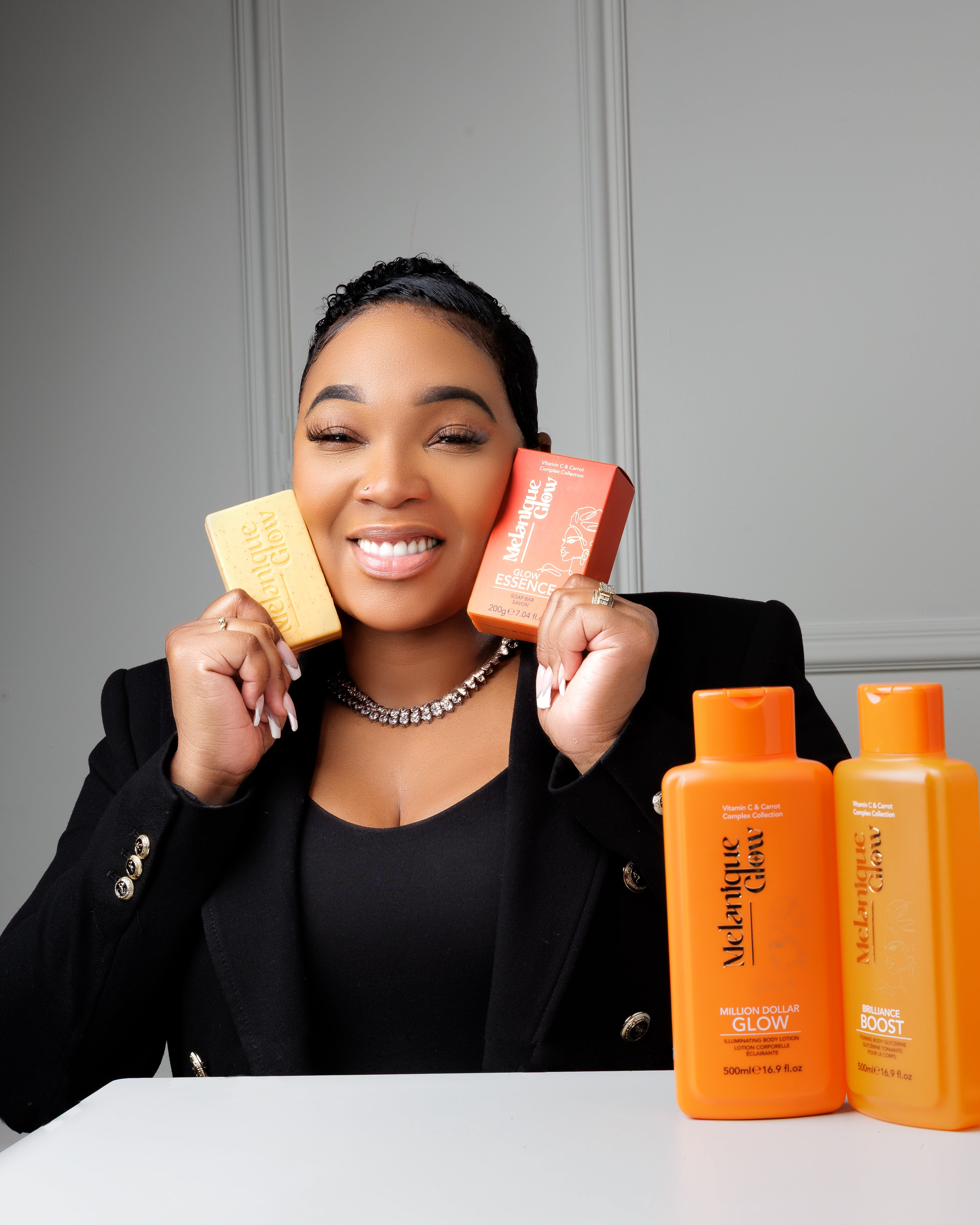 Founder holding two bars of Melanique Glow soap.