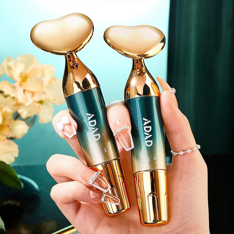 Two gold heart-headed massagers with teal bodies marked ADAD held in one hand