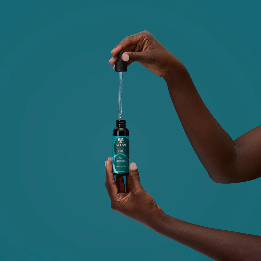 As I Am Bond Repair Hair Oil bottle with dropper in use