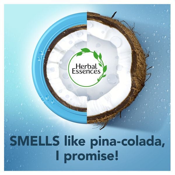 Halved coconut inside a blue tub with the Herbal Essences logo and the caption smells like pina-colada, I promise
