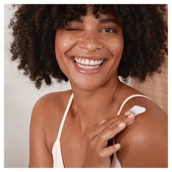 Nivea Woman applying body cream to shoulder